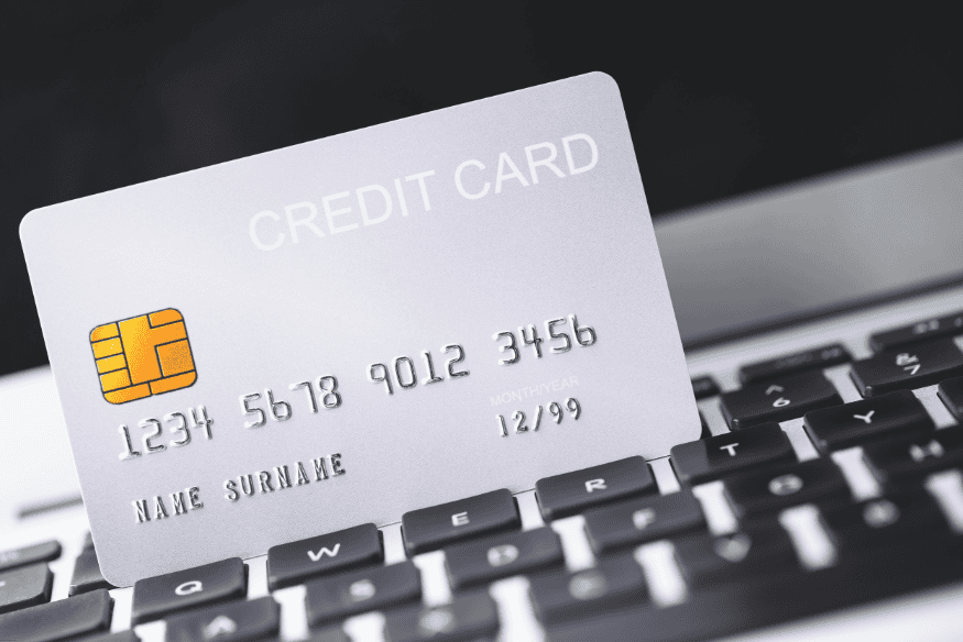 Close-up of a white credit card on a keyboard, symbolizing digital finance and e-commerce.