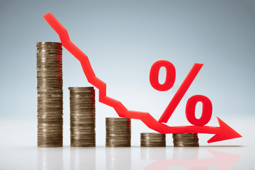 Stacks of coins decreasing in height with a red percentage symbol and downward arrow.