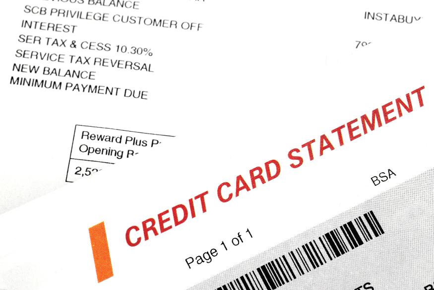 Close-up of a printed credit card statement showing balance and charges