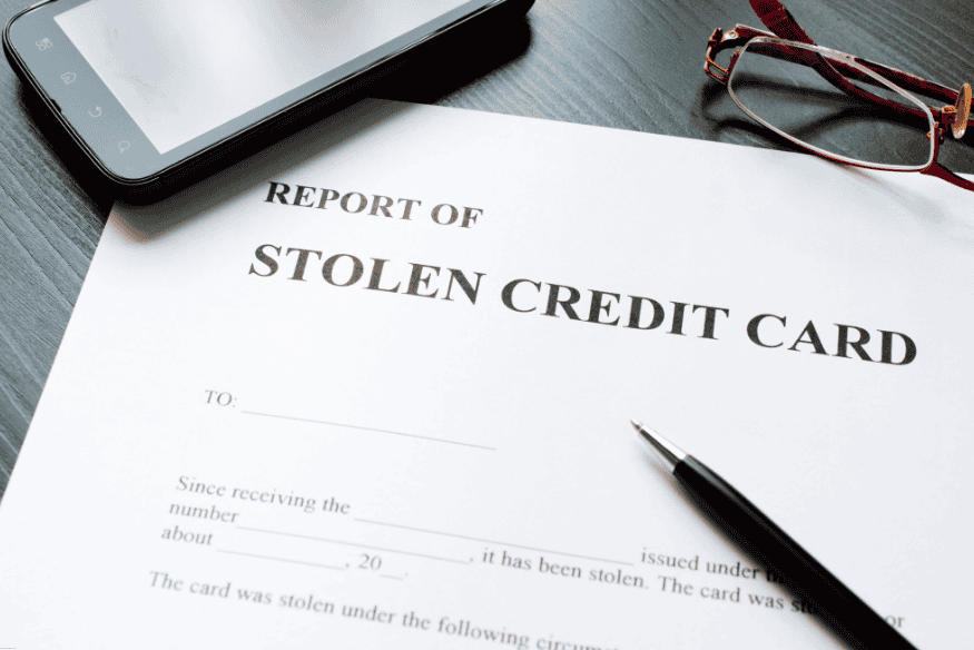 Stolen credit card report form with pen, smartphone, and eyeglasses