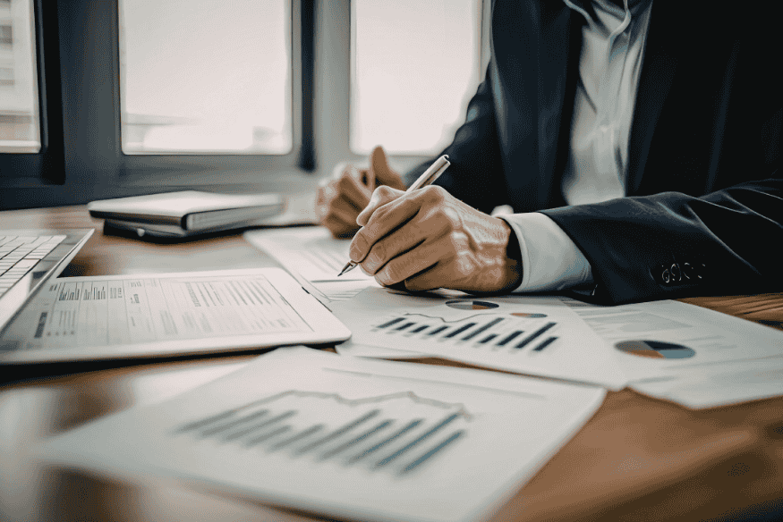 Person taking notes over financial charts during a 20-minute weekly personal finance review session